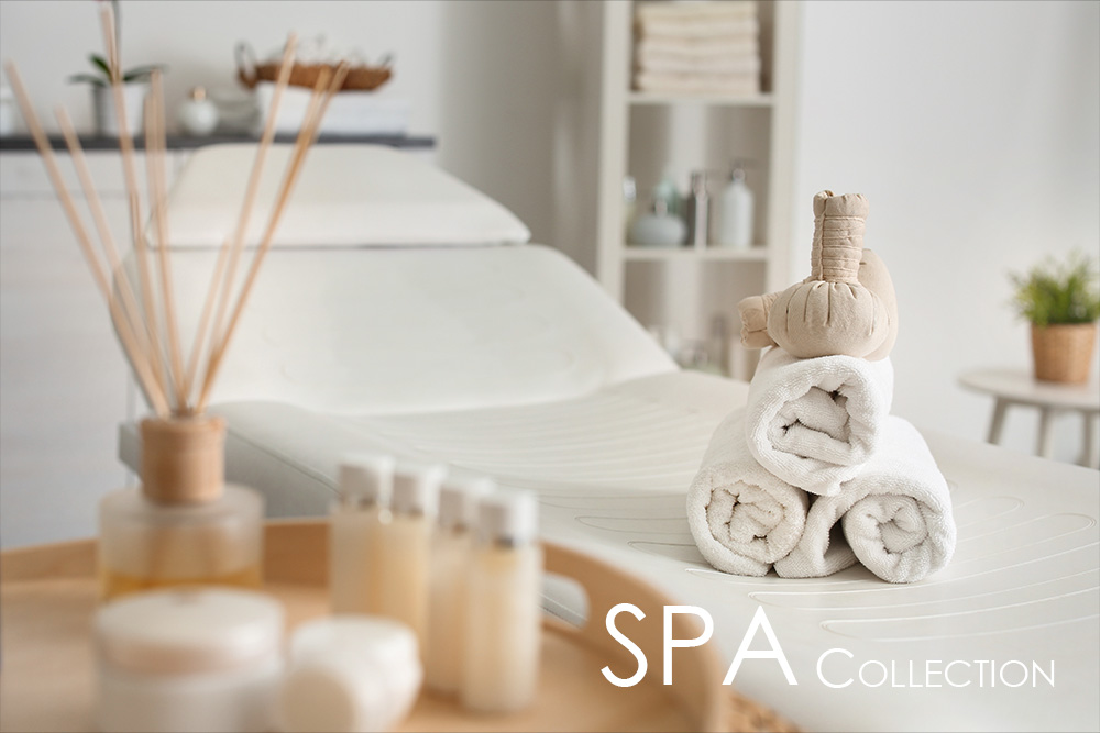Stimmungsvolles Spa-Ambiente mit weißen Handtüchern, Massageutensilien und Pflegeprodukten auf einem Behandlungstisch – Symbolbild der NEOVITA SPA Collection für ganzheitliche Entspannung und luxuriöse Körperpflege.
